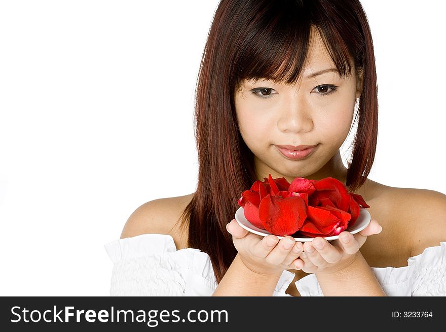 An attractive young Asian woman in white top holding a red flower on white background. An attractive young Asian woman in white top holding a red flower on white background