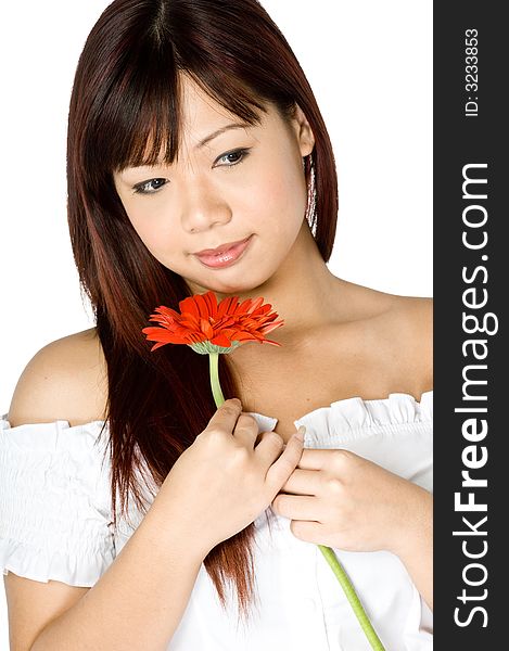 An attractive young Asian woman in white top holding a red flower on white background. An attractive young Asian woman in white top holding a red flower on white background