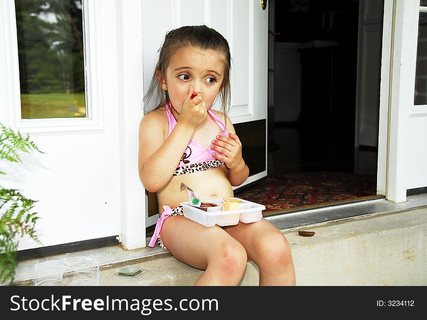 Cute little girl taking time out for a snack. Cute little girl taking time out for a snack.