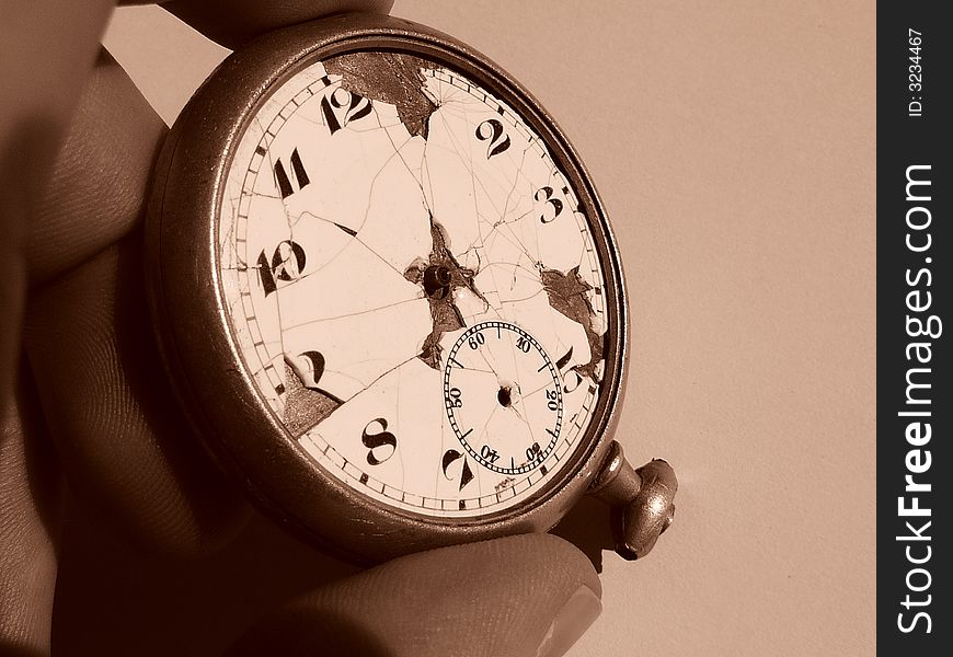 A broken antique pocketwatch held by a hand trying to determine the time. A broken antique pocketwatch held by a hand trying to determine the time.