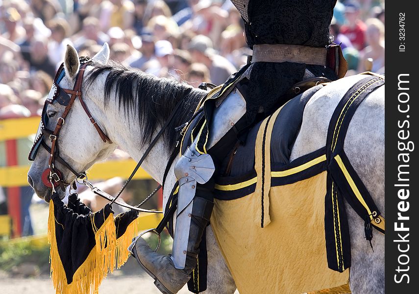 A horse has a rider in full dress gear. A horse has a rider in full dress gear.