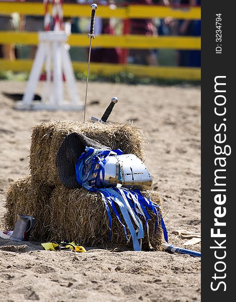 A knight's helment lays on a bale of hay. A knight's helment lays on a bale of hay