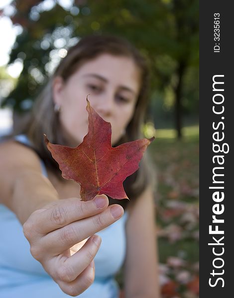 Woman showing the details on a red leaf