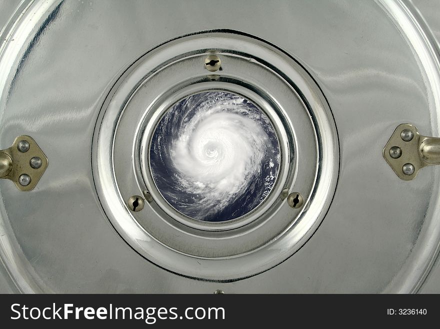 Cyclone seen through the small round circle window in a metal cover. Image of typhoon used under Terms and Conditions of Nasa http://visibleearth.nasa.gov. Cyclone seen through the small round circle window in a metal cover. Image of typhoon used under Terms and Conditions of Nasa http://visibleearth.nasa.gov