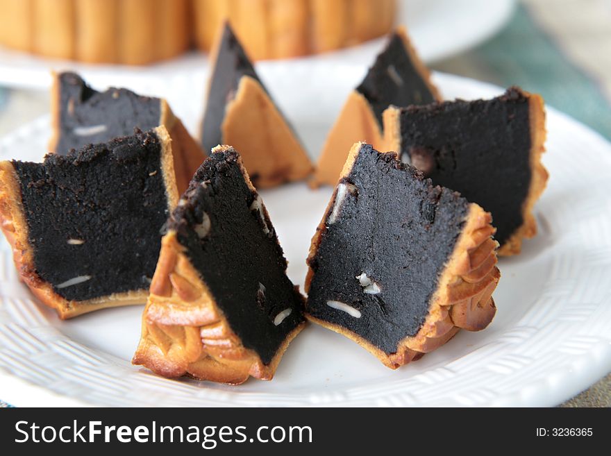 Wedge shaped portions of Chinese mooncake with red bean paste and melon seed filling