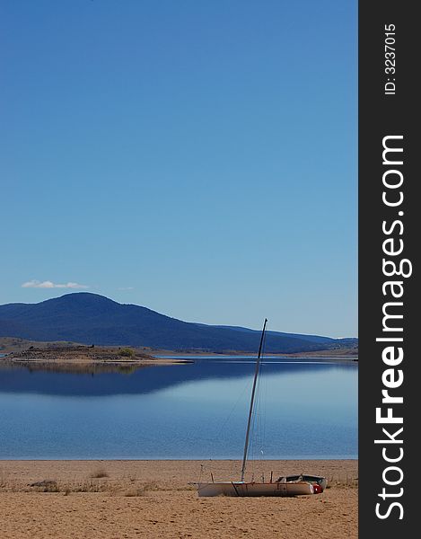 Sailing boat sitting on the sandy beach of a lake shore. Sailing boat sitting on the sandy beach of a lake shore