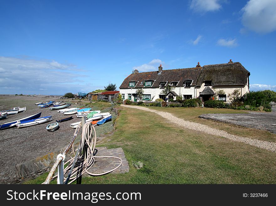 An English Seaside resort with Boats moored on a shingle beach waiting for the Tide. An English Seaside resort with Boats moored on a shingle beach waiting for the Tide