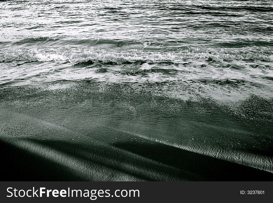 Snadows on the sand and waves breaking. Snadows on the sand and waves breaking