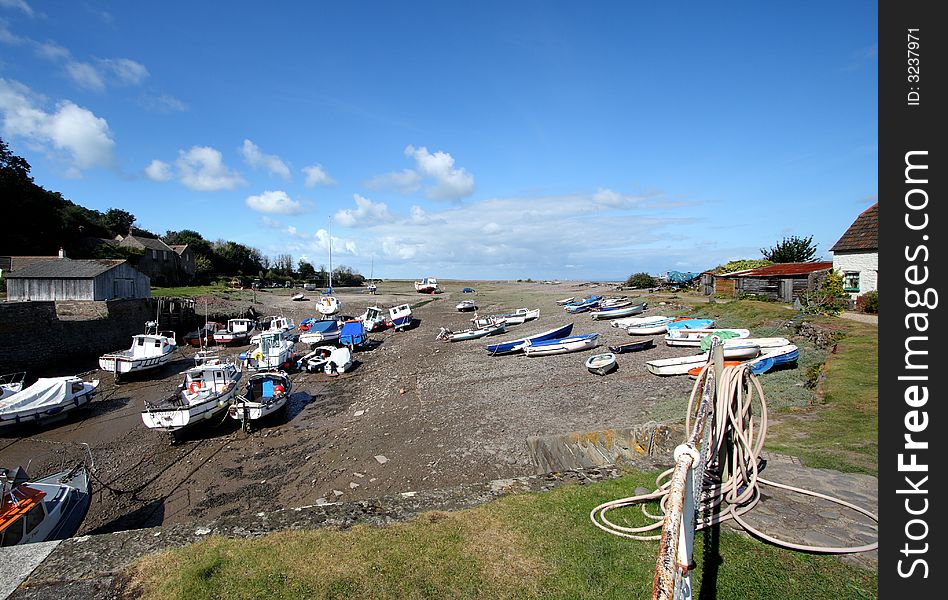 An English Seaside resort with Boats moored on a shingle beach waiting for the Tide. An English Seaside resort with Boats moored on a shingle beach waiting for the Tide