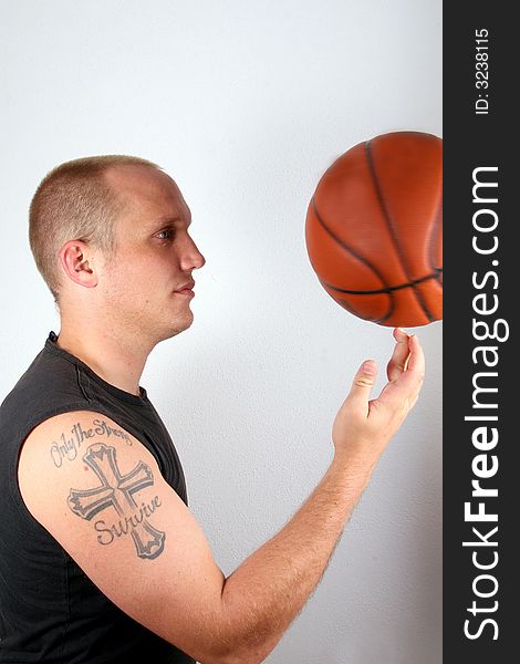 A young man with bright blue eyes and a basketball spinining on his finger! Isolated over white!. A young man with bright blue eyes and a basketball spinining on his finger! Isolated over white!
