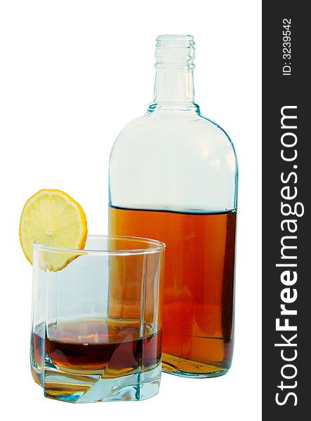 Bottle of cognac, glass with cognac and a lemon