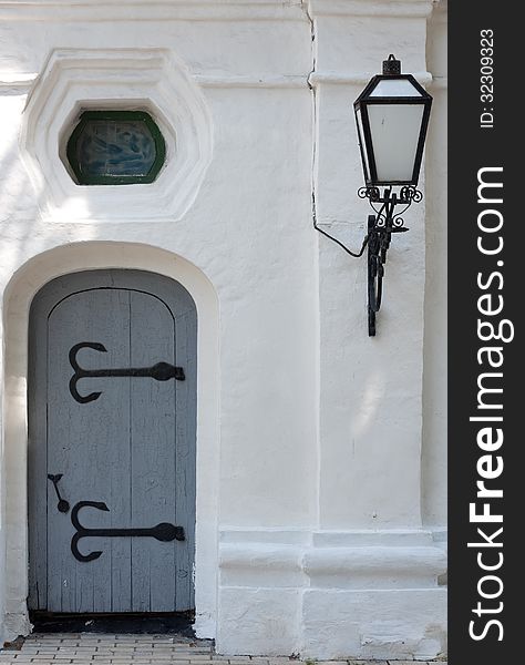 Ancient door with a lamp .