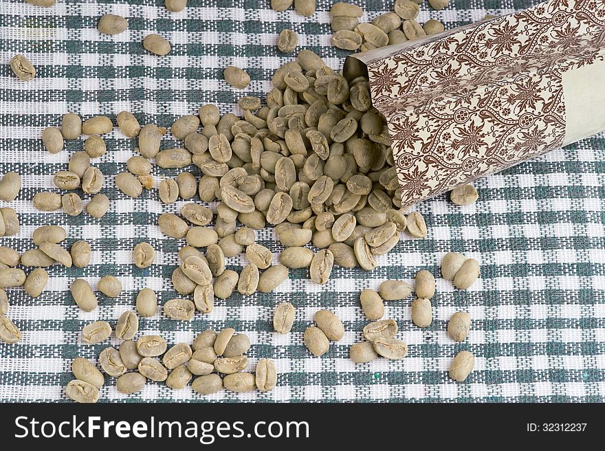 Heap of not roasted coffee beans on tablecloth. Maragogype. Heap of not roasted coffee beans on tablecloth. Maragogype.