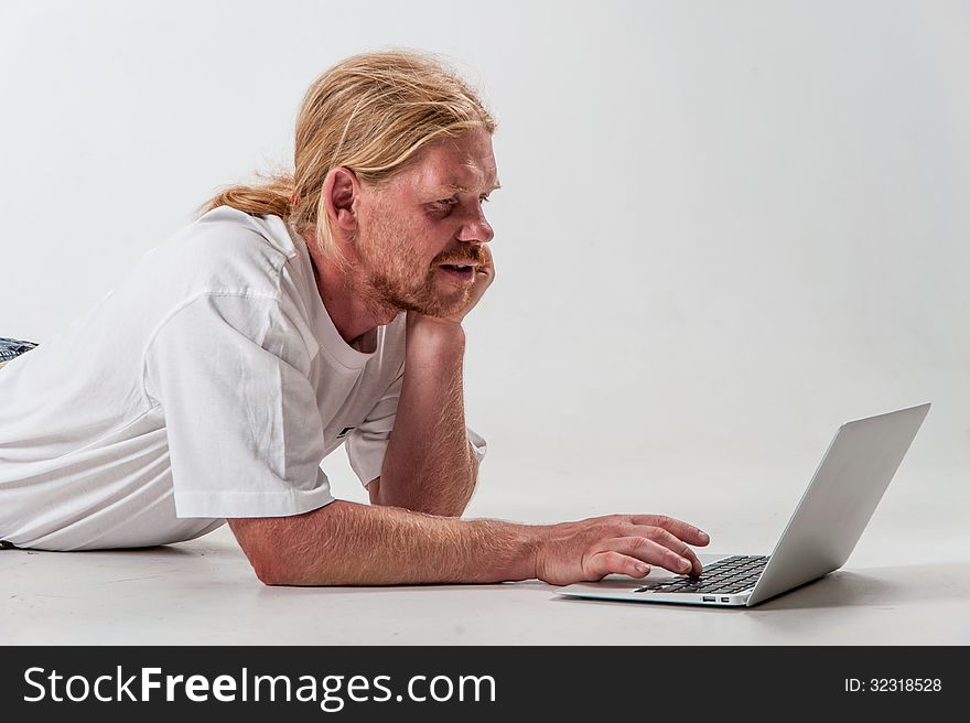 Serious man with laptop on the white background