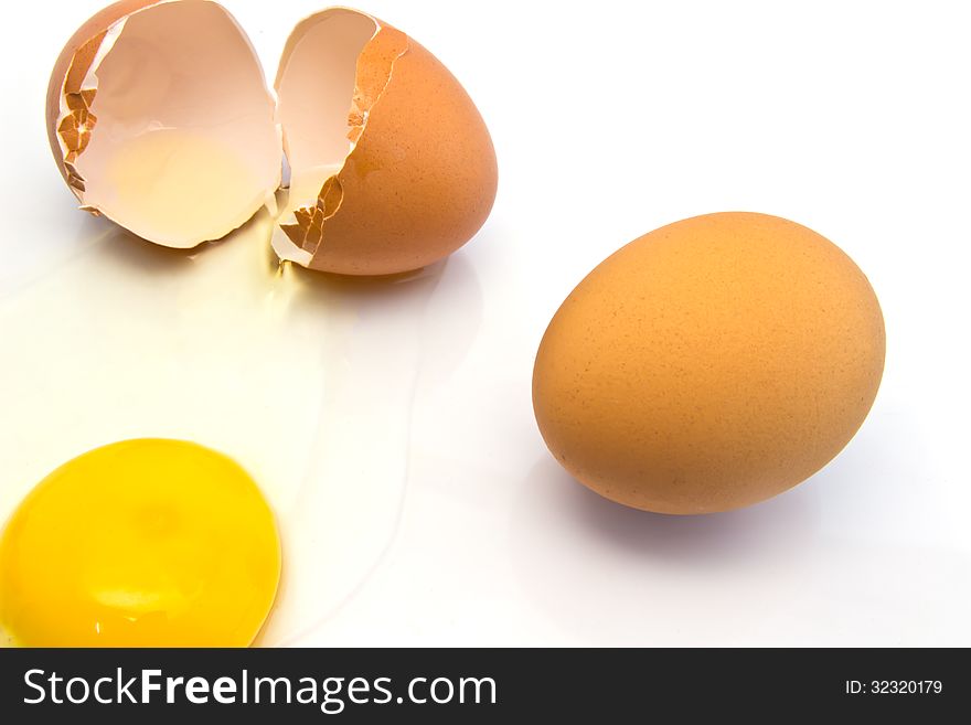 Cracked fresh hens egg with the bright yellow yolk and transparent albumin or egg white running over a white. Cracked fresh hens egg with the bright yellow yolk and transparent albumin or egg white running over a white