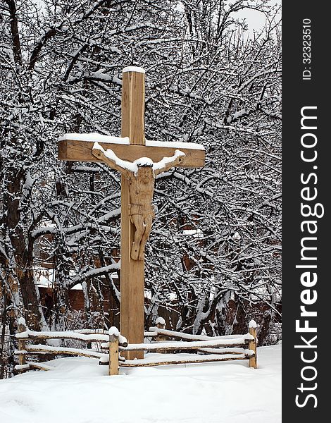 Wooden carved crucifix under the snow
