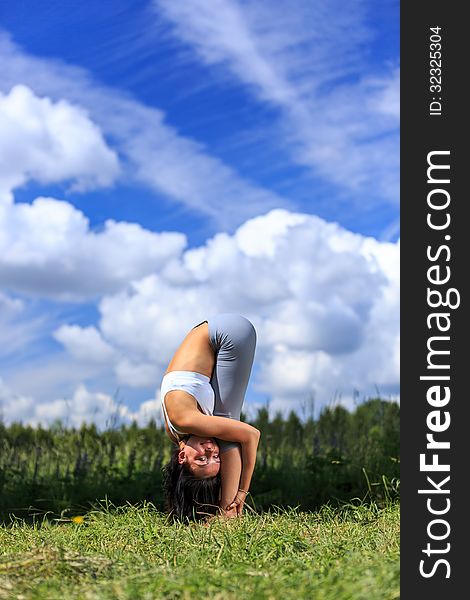 Girl doing yoga outdoor looking in camera, vertical. Girl doing yoga outdoor looking in camera, vertical