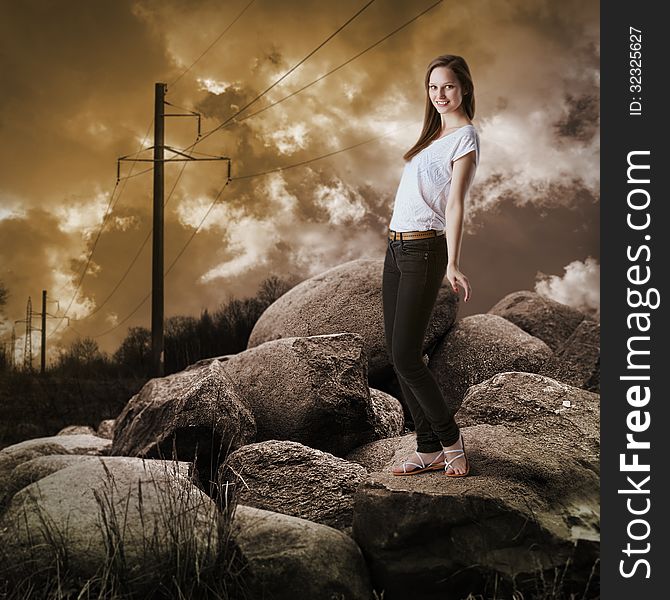 Young girl in jeans standing on large rocks. Young girl in jeans standing on large rocks