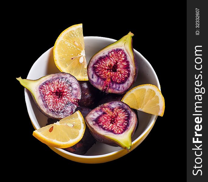 Fruits figs and lemons on black background