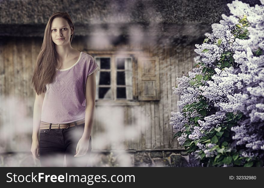 Portrait of a young girl on the background of the rural house and lilac bush. Portrait of a young girl on the background of the rural house and lilac bush