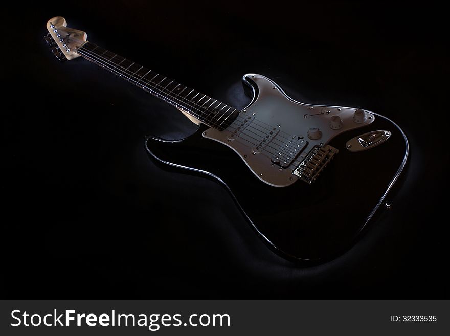 A Black guitar outlined over a dark background. A Black guitar outlined over a dark background