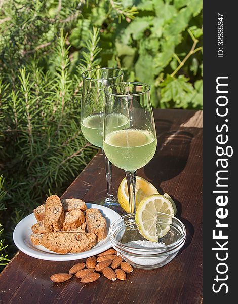 Limoncello - Italian lemon liqueur typically served with biscotti - oblong-shaped almond biscuits. Limoncello - Italian lemon liqueur typically served with biscotti - oblong-shaped almond biscuits