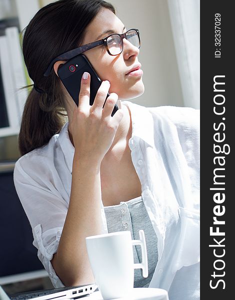 Woman talking on mobile phone at work
