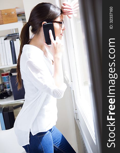 Businesswoman talking on mobile phone at work