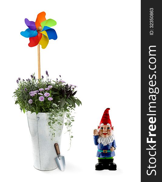 Spring flowers in an aluminum bucket with a toy windmill and gnome. Spring flowers in an aluminum bucket with a toy windmill and gnome