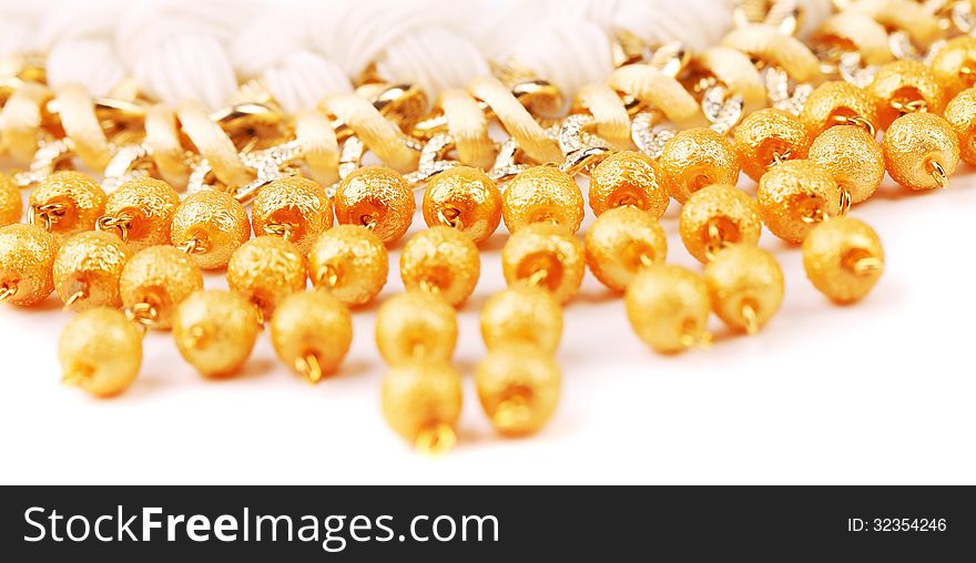 Necklace Of Gold Pearls On A White Bacground
