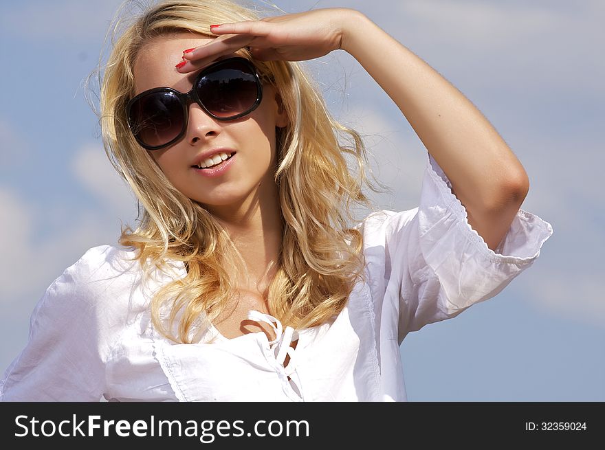 Portrait of beautiful blonde girl on background blue sky. Portrait of beautiful blonde girl on background blue sky