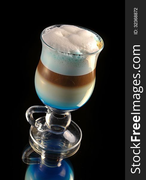 Cocktail with coffee and whipped milk and liqueur curacao