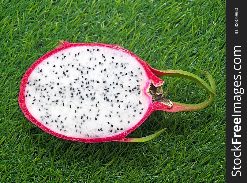 Vivid Dragon fruit isolated on a green grass. Vivid Dragon fruit isolated on a green grass