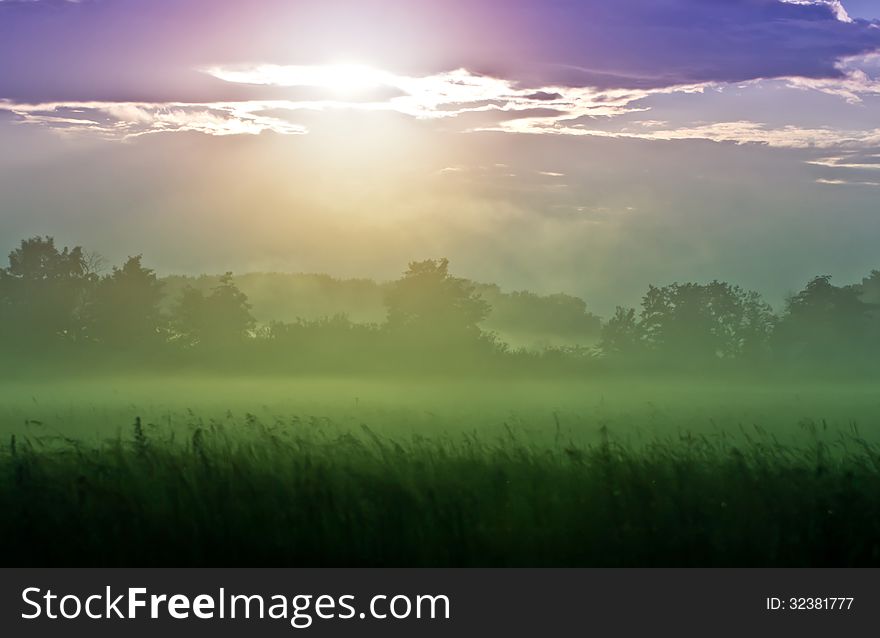 Lilac sunset over a foggy valley