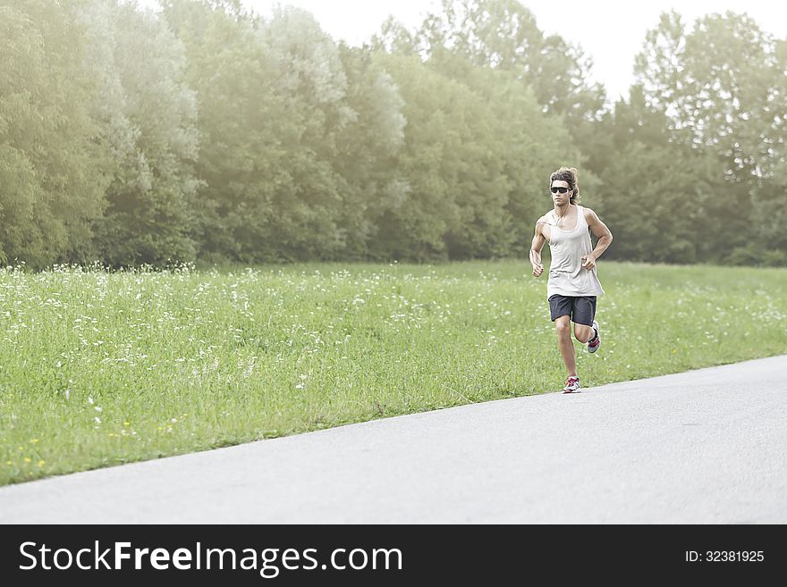 Athlete runs on the road with sunglasses