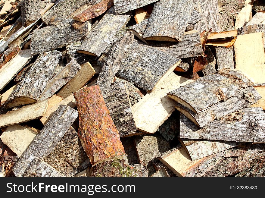 Various wood firewood stacked in a pile. Various wood firewood stacked in a pile