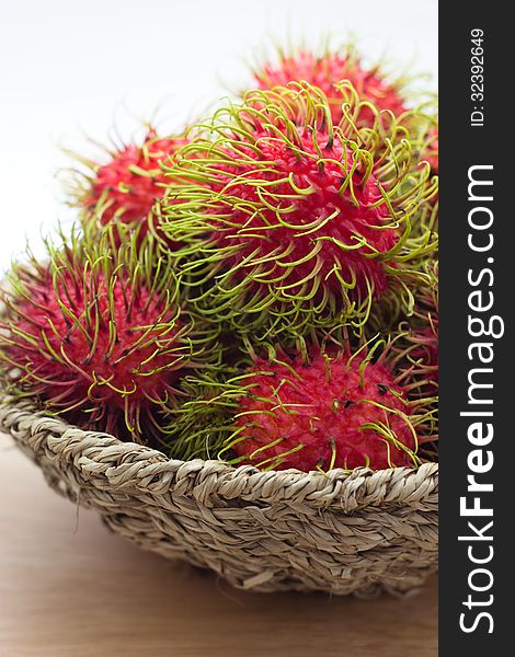 Rambutan in bamboo basket isolated on white background. Rambutan in bamboo basket isolated on white background