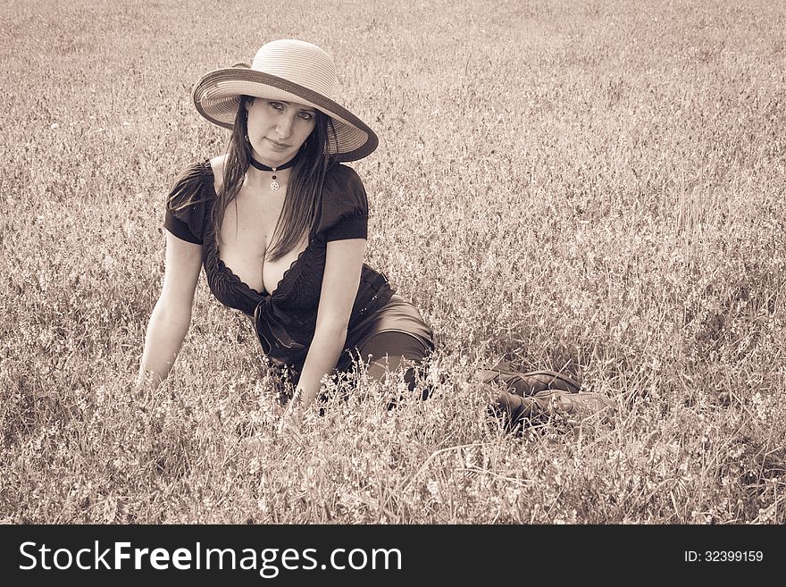 Beautiful caucasian woman sitting on the grass on summer meadow. Beautiful caucasian woman sitting on the grass on summer meadow.