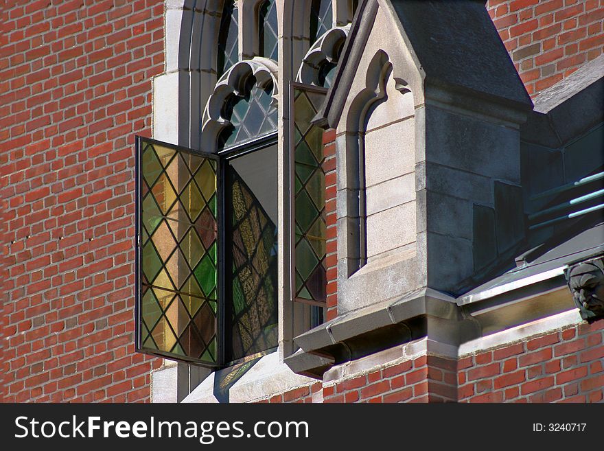 Beautiful opened stained glass window on a old chapel. Intricate architecture on chapel. Beautiful opened stained glass window on a old chapel. Intricate architecture on chapel.