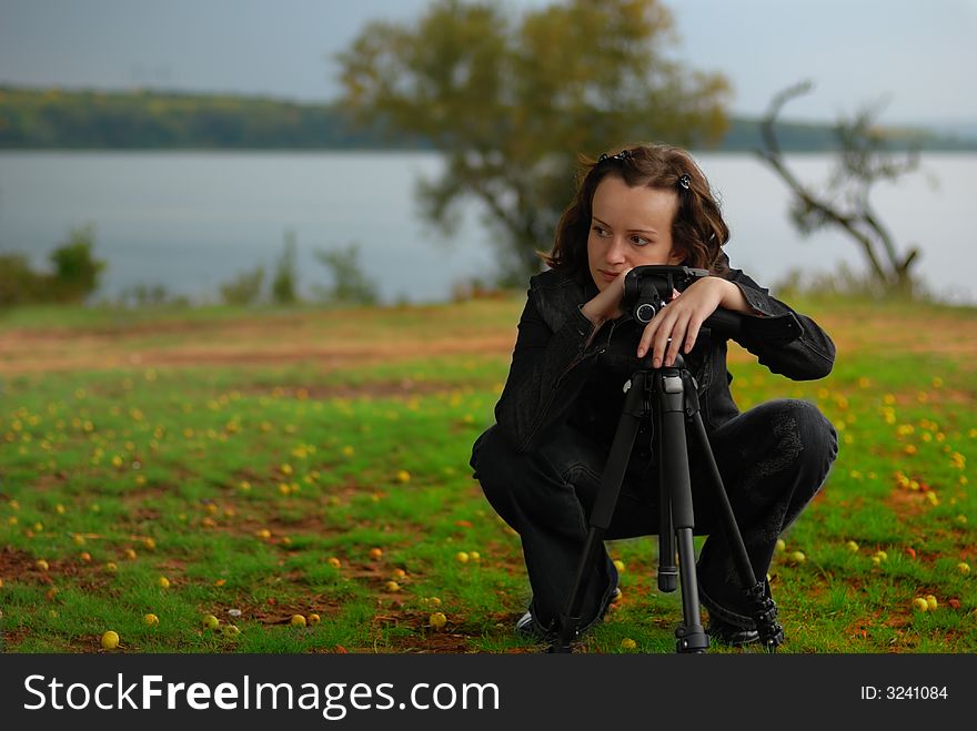 The girl - the photographer. The girl considers construction of a picture, early autumn