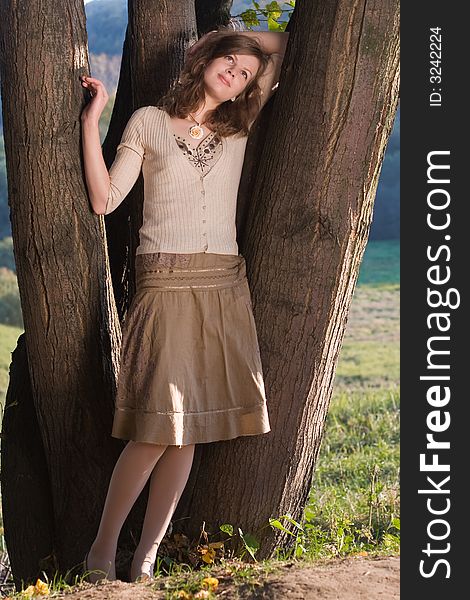 Smiling girl stand near tree. Smiling girl stand near tree