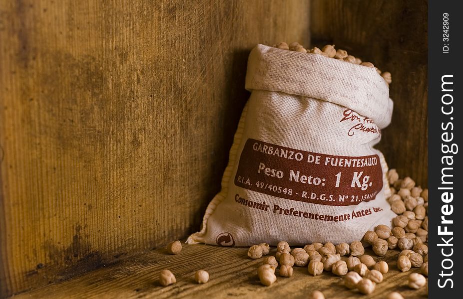 A small sack of Spanish grown garbanzo beans (chickpeas) in a rustic looking old wooden crate. A small sack of Spanish grown garbanzo beans (chickpeas) in a rustic looking old wooden crate.
