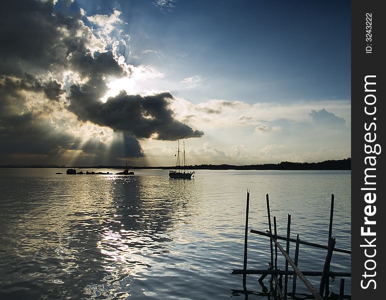 Sun beams radiating from behind a cloud as seen from a boardwalk close to sunset. Sun beams radiating from behind a cloud as seen from a boardwalk close to sunset