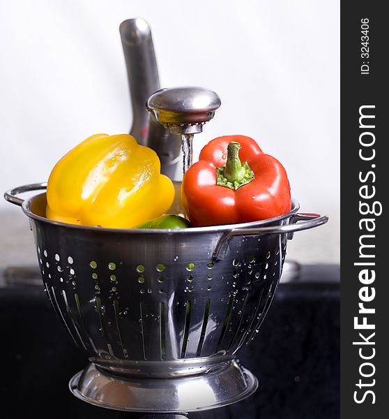 Healthy Kitchen Detail with colander full of fresh peppers being prepped for salad.