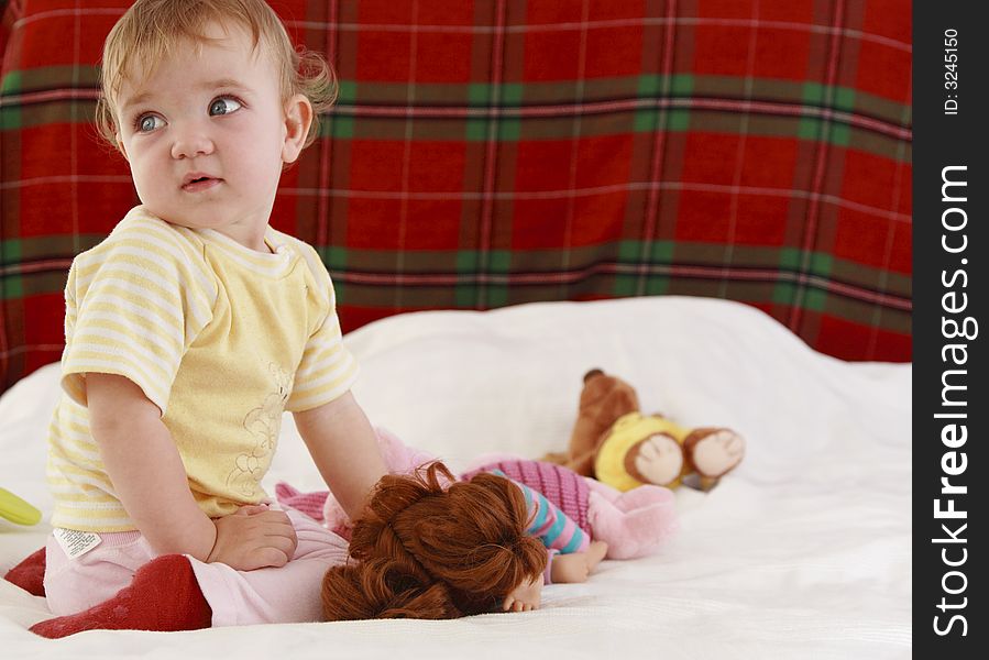 A baby is playing on a bed. A baby is playing on a bed.