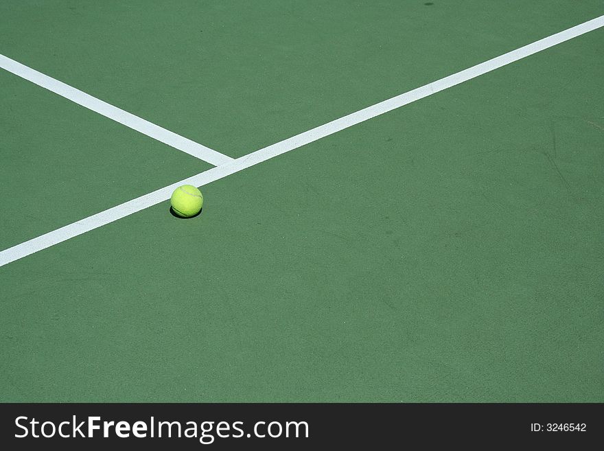 A Tennis ball on a green court