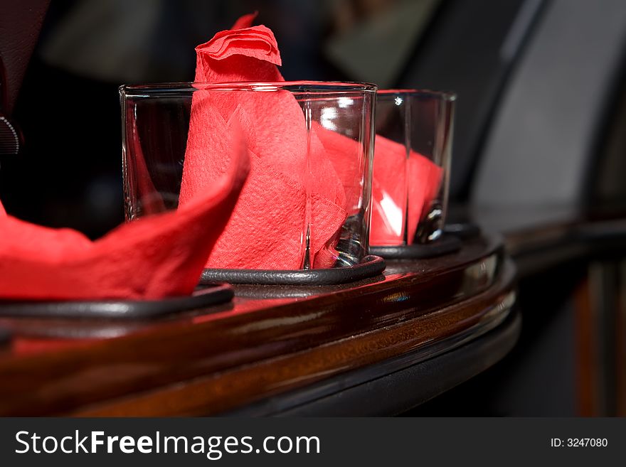 Glasses in the bar rack with red napkins inside