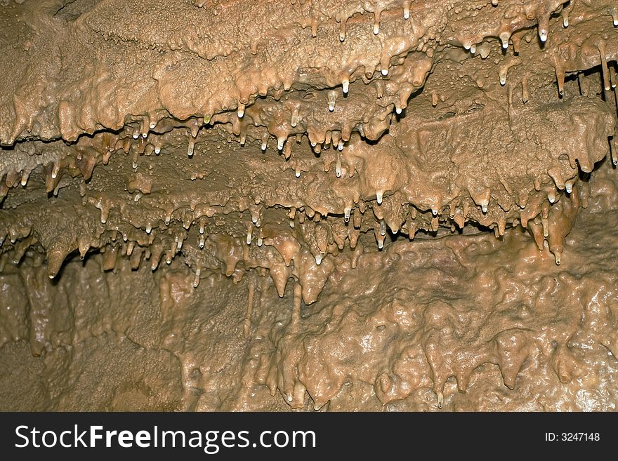 Young stalactites hang from the ceiling in Smoke Hole Caverns, WV. The slight red coloring is from iron deposits.