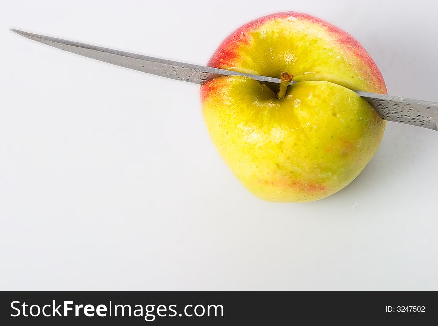 A knife is kutting apples. A knife is kutting apples.