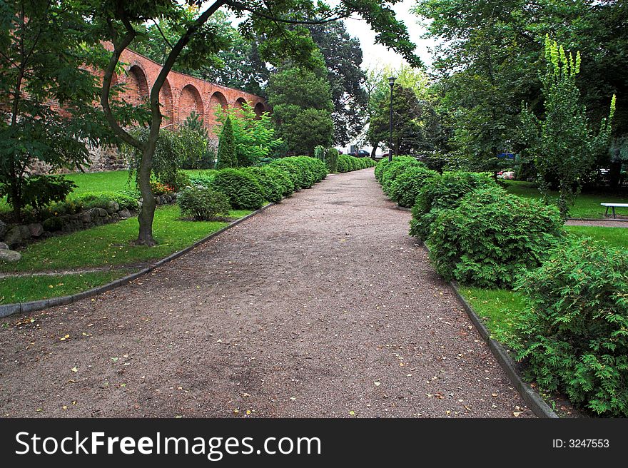 Alley in park with flowers and wall